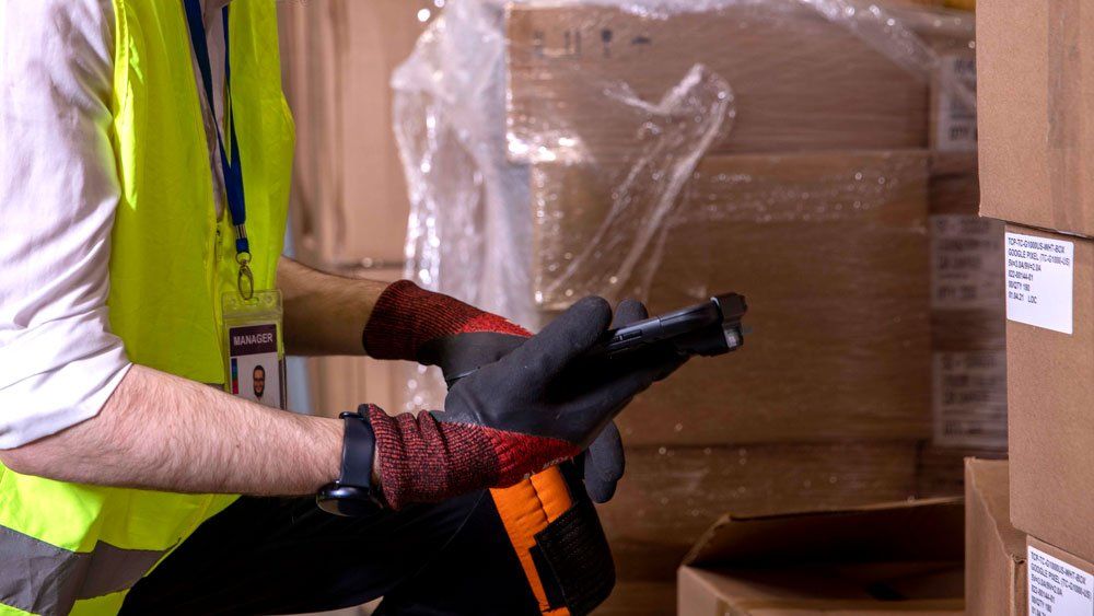 worker wearing gloves using mobile computer barcode scanner