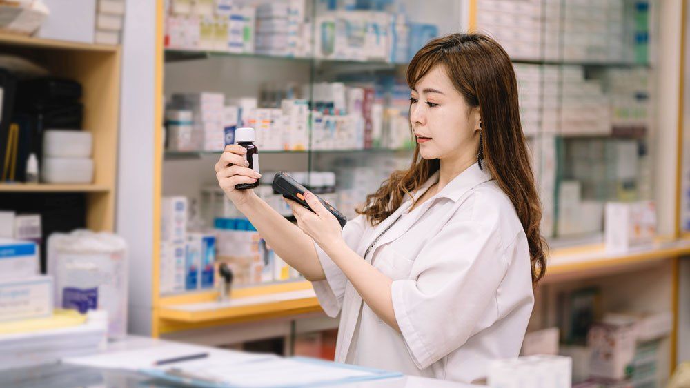 healthcare worker in pharmacy scanning with mobile computer