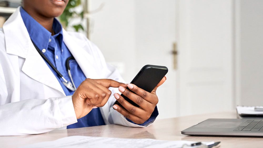 Nurse and Doctor using rugged phone while at desk