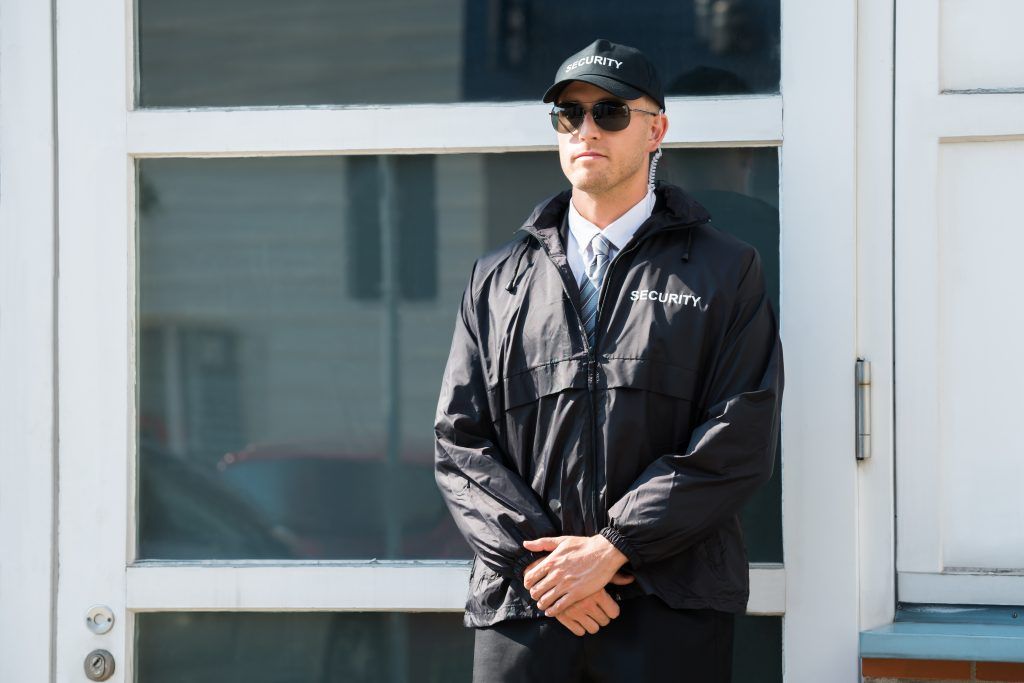 security man standing in front of building from agency