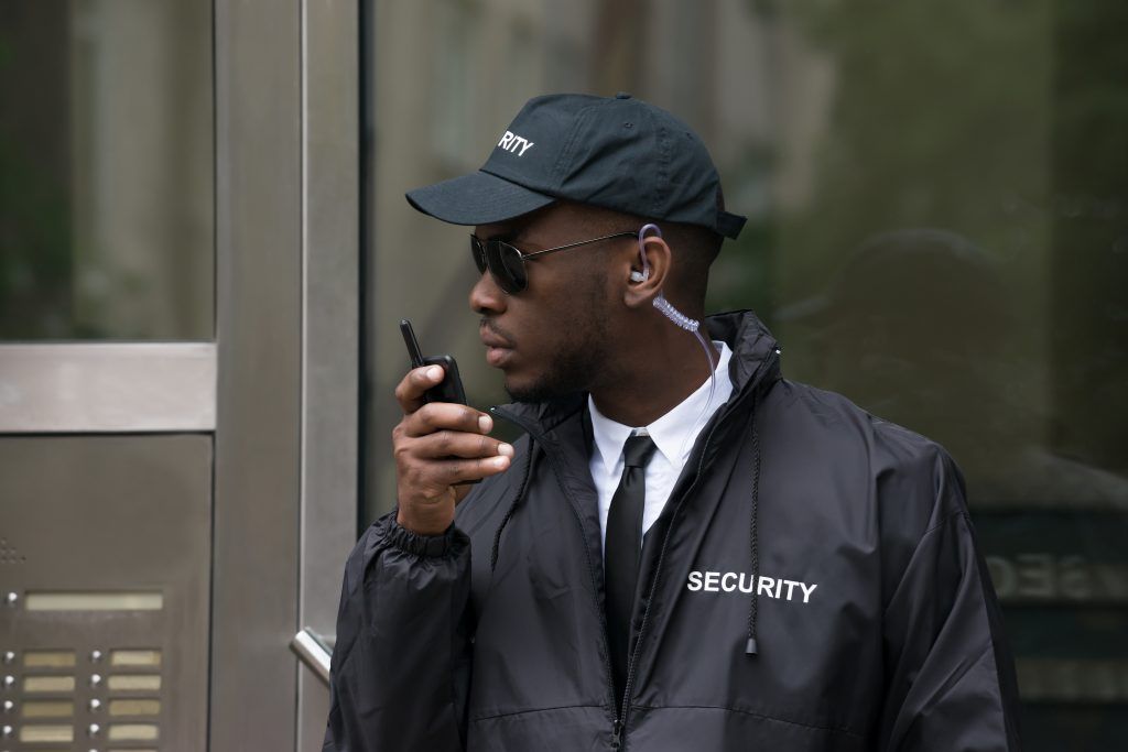 Security worker man using rugged phone for job
