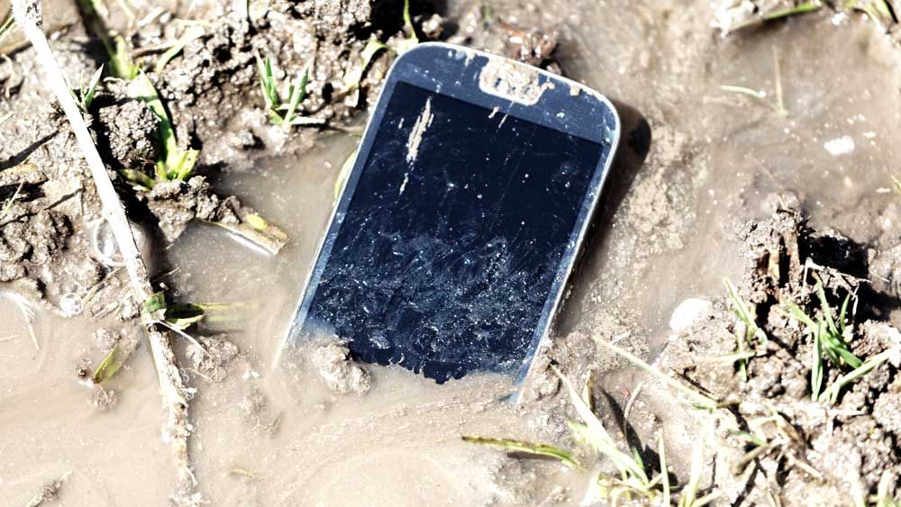 rugged smartphone in mud and dirt