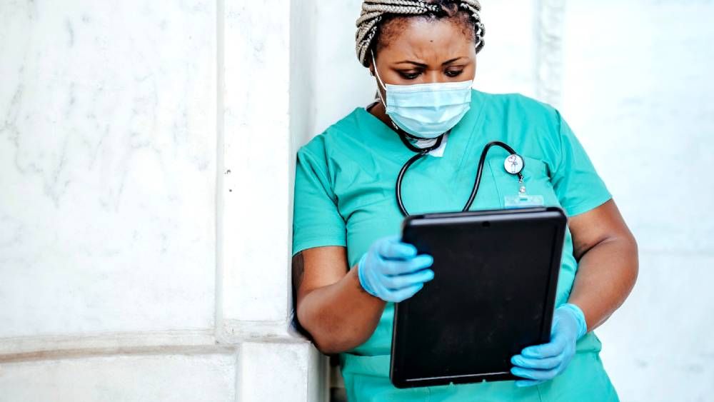 Nurse using large tablet for nursing work in hospital