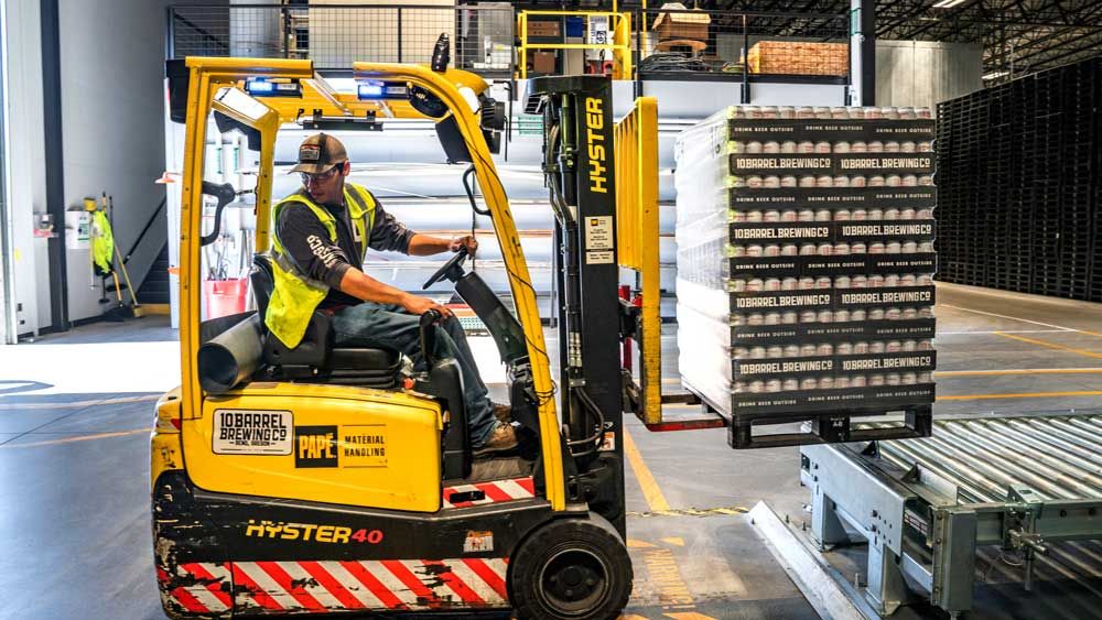 man uses fork lift in warehouse