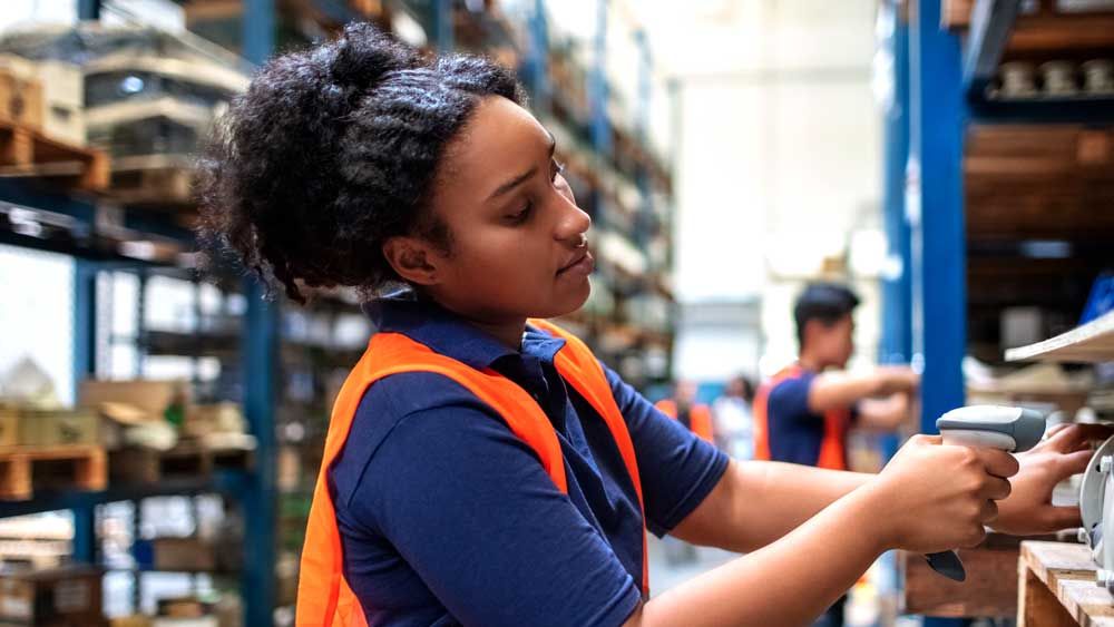 woman worker scanning item in warehouse using barcode scanner