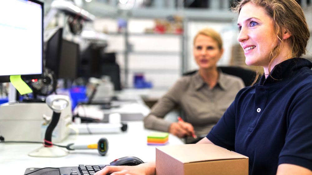 woman using computer in warehouse
