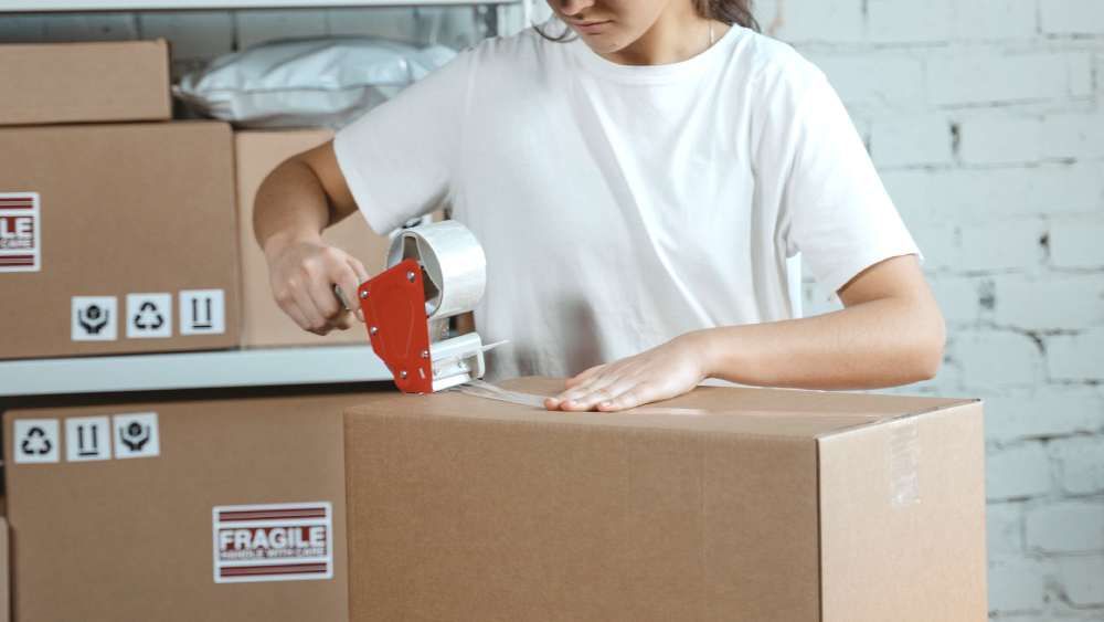 woman worker packages box in warehouse