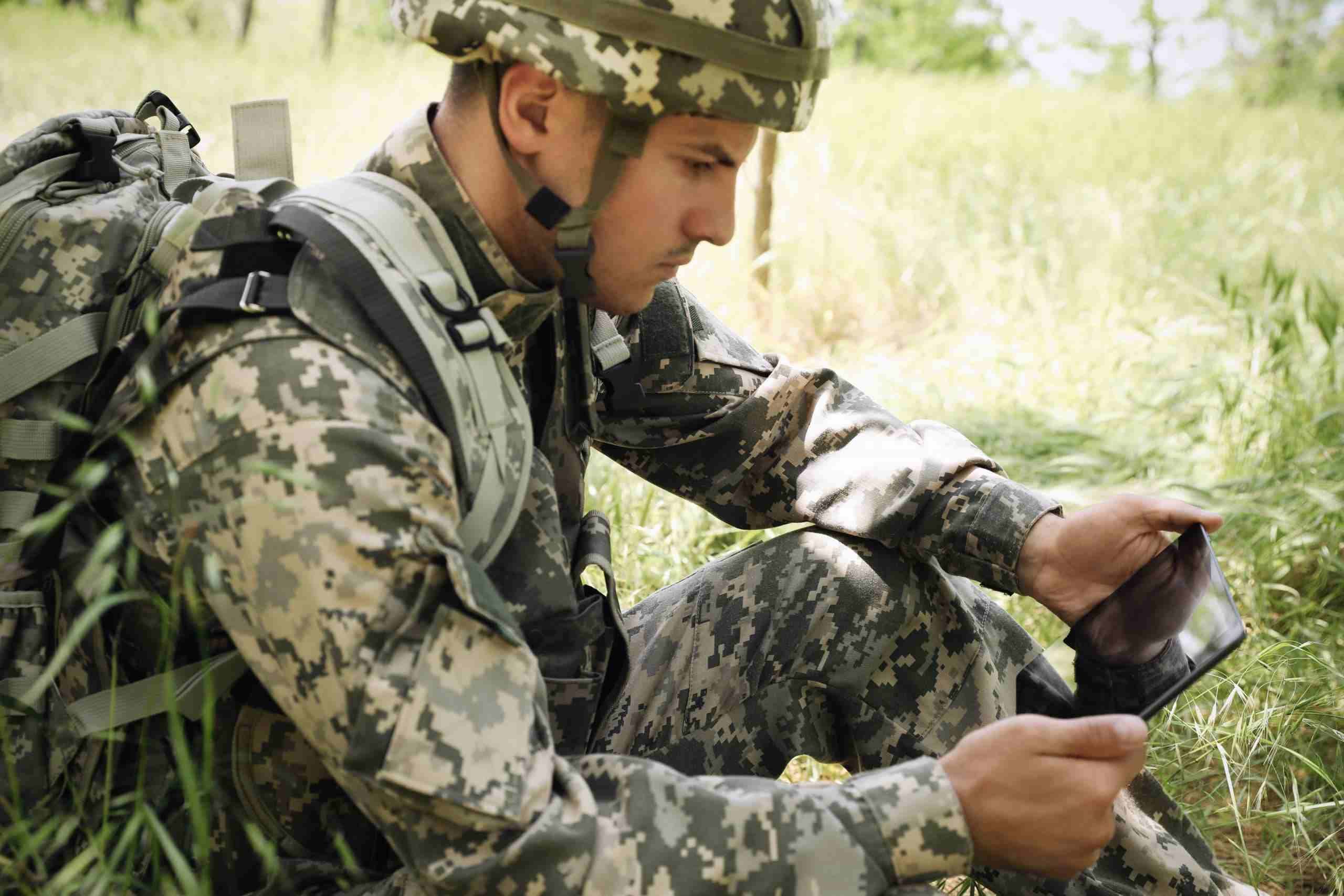 soldier in camo using military tablet