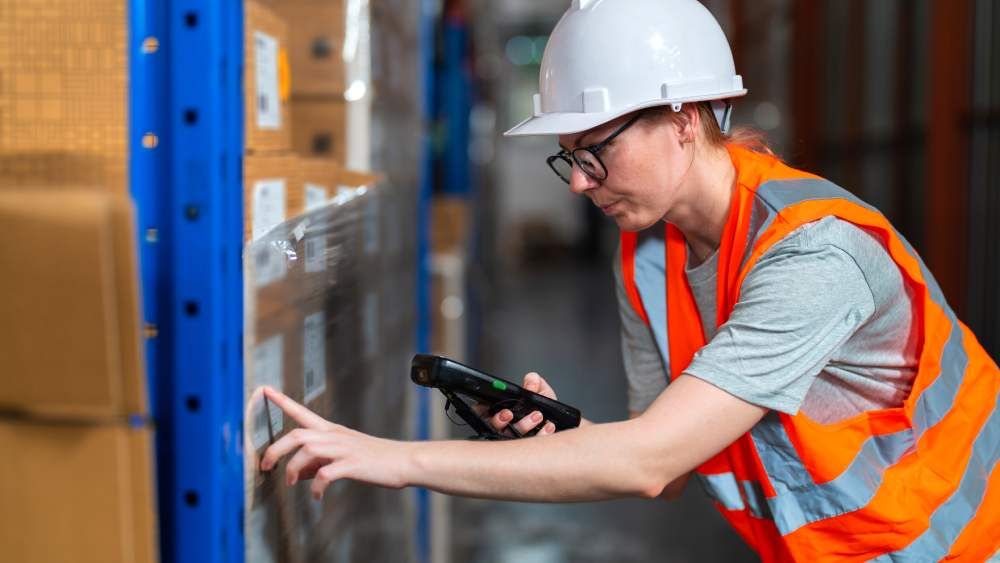 Warehouse worker checking stock using barcode scanner
