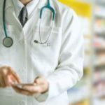 a male doctor operate his phone at 
 pharmacy