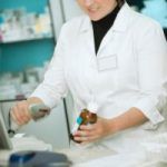 pharmacy worker checking price of the medicine bottle