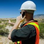 Construction worker in a field using phone
