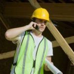 A construction worker is talking on the phone